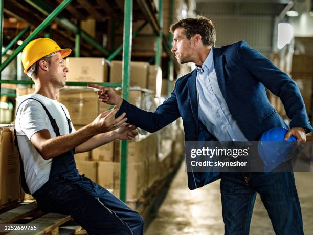 frustrated inspector threatening his worker in distribution warehouse. - infectious disease threat stock pictures, royalty-free photos & images