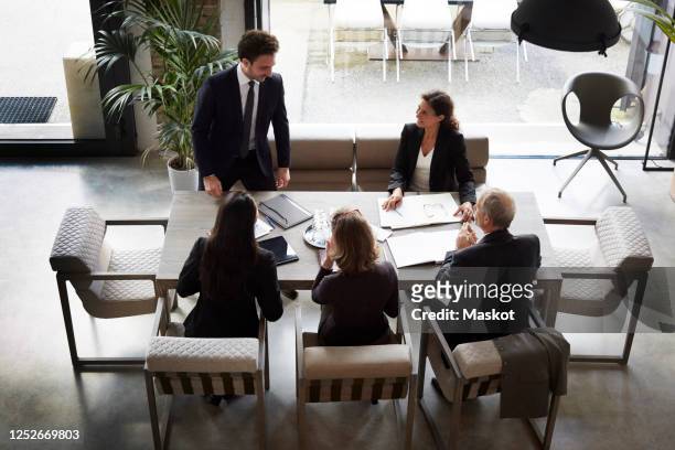 high angle view of financial advisors with businessman and businesswoman planning at office during meeting - corporate lawyer stock pictures, royalty-free photos & images