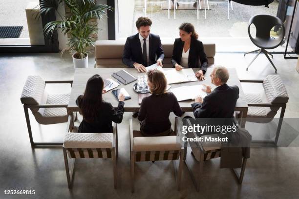 high angle view of financial advisors and customers discussing during meeting at law firm - law firm stock pictures, royalty-free photos & images