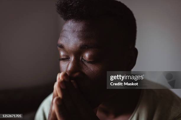 close-up of worried man with eyes closed at home - homme triste photos et images de collection