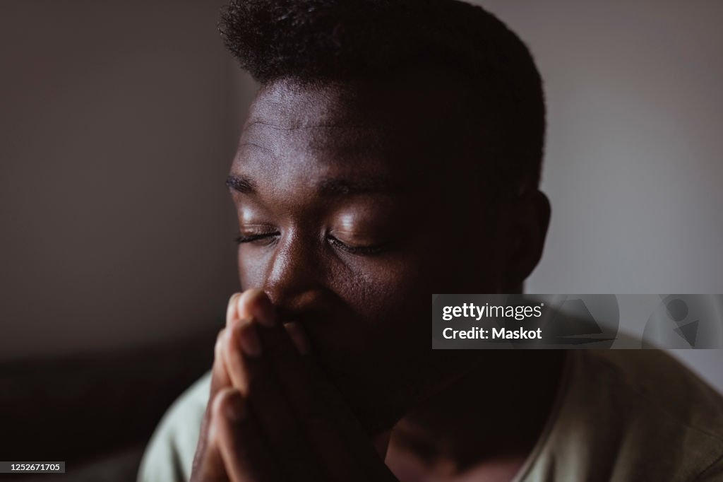 Close-up of worried man with eyes closed at home
