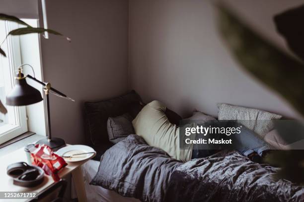 rear view of sad man sleeping on bed - essstörung stock-fotos und bilder