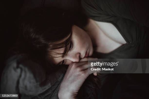 close-up of sad woman lying on bed - tristeza imagens e fotografias de stock