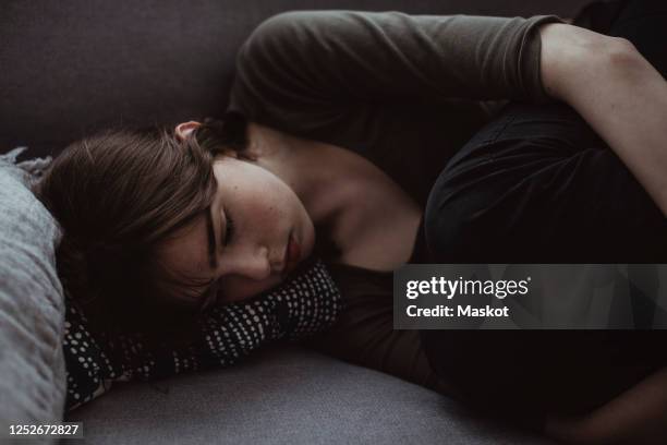 sad woman on sofa at home - woman-lying-on-side-unhappy stock pictures, royalty-free photos & images
