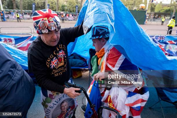 Royalists John Loughrey quickly pulls a tarpaulin over his friends as it begins to rain as people gather along The Mall in preparation for the...