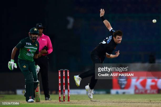 New Zealand's Matt Henry bowls as Pakistan's captain Babar Azam looks on during the fourth one-day international cricket match between Pakistan and...