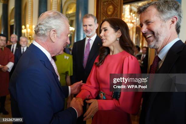 King Charles III greets Mary, Crown Princess of Denmark and Crown Prince Frederik of Denmark, during a reception at Buckingham Palace for overseas...