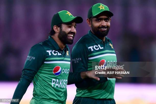 Pakistan's captain Babar Azam and his teammate Mohammad Rizwan celebrate after winning the fourth one-day international cricket match between...