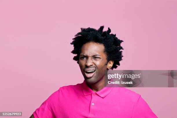 headshot of upset man wearing pink polo shirt - disgust stock pictures, royalty-free photos & images