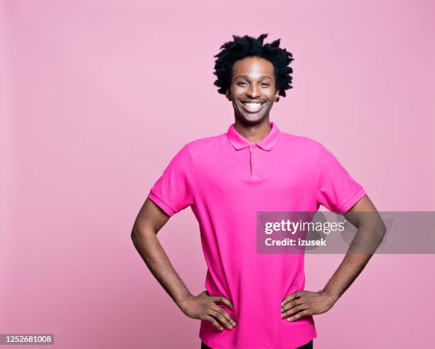 portrait of excited young man wearing pink polo shirt - cheesy grin stock pictures, royalty-free photos & images