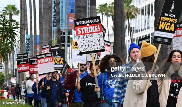 Writers on strike march with signs on the picket line on day four of the strike by the Writers Guild of America in front of Netflix in Hollywood,...