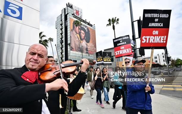 Mariachi Band performs on Cinco De Mayo as writers on strike march with signs on the picket line on day four of the strike by the Writers Guild of...