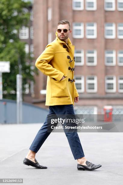 Influencer Andre Borchers wearing a yellow wool and cashmere duffle coat by Gucci, a multicolored shirt by Zara, dark blue pants by H&M, black...