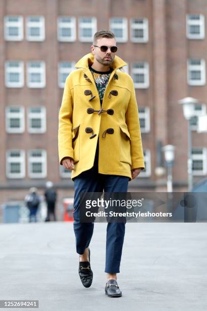 Influencer Andre Borchers wearing a yellow wool and cashmere duffle coat by Gucci, a multicolored shirt by Zara, dark blue pants by H&M, black...