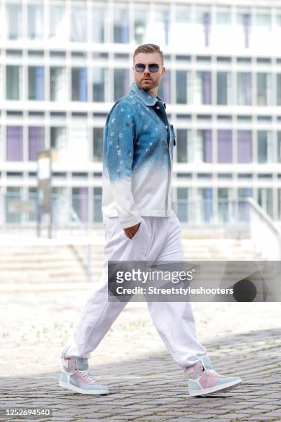 Influencer Andre Borchers wearing white sweatpants by Off-white, a blue to white gradient denim jeans shirt in workwear style with monogram...