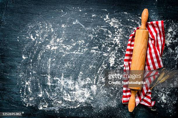 cooking backgrounds: rolling pin on checkered napkin shot from above on black background. copy space - chef table imagens e fotografias de stock