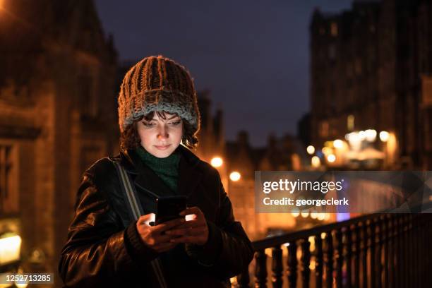 texting at dusk - weather app stock pictures, royalty-free photos & images