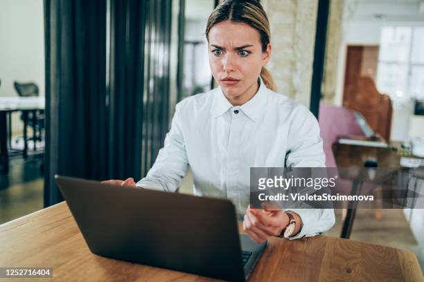 verwarde onderneemster die laptop bekijkt. - confused woman stockfoto's en -beelden