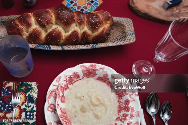 overhead shot of a table with a loaf of challah and a plate on it. - challah stock pictures, royalty-free photos & images