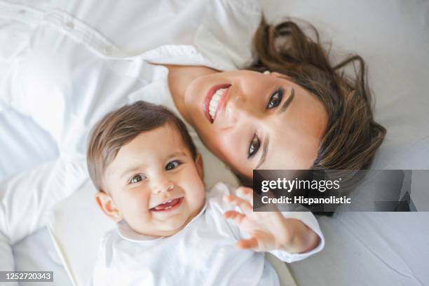 portrait of mommy and daughter facing camera cheerfully while lying down - woman smiling facing down stock pictures, royalty-free photos & images