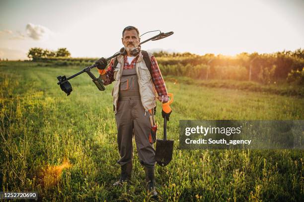 un homme aîné sur une chasse au trésor - treasure hunt photos et images de collection