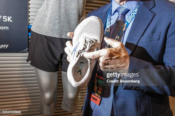 Jim Weber, chief executive office of Brooks Running Co., hold a shoe at the company's booth during a shareholders shopping day ahead of the Berkshire...