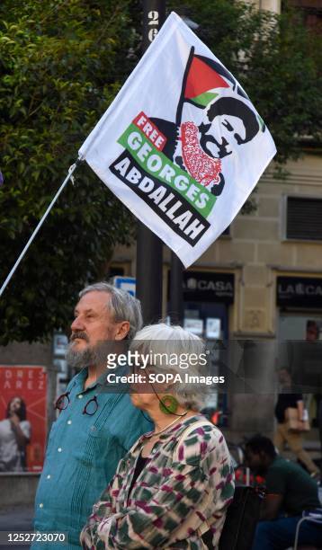 Middle-aged couple waves a flag for the freedom of Georges Abdallah during the demonstration. Protest in the Madrid neighborhood of Lavapies against...