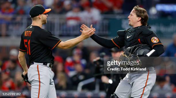 Austin Voth reacts with Adley Rutschman of the Baltimore Orioles at the conclusion of the 9-4 victory over the Atlanta Braves at Truist Park on May...