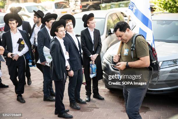 Haredi orthodox youth looks at a reservist against the judicial reform during a protest against Haredi orthodox IDF exemption.