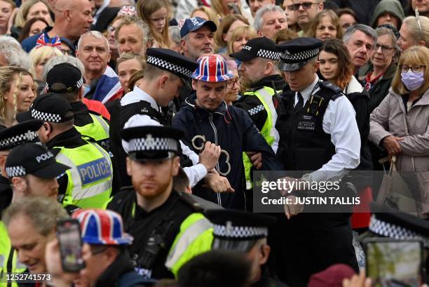 Protesters from climate protest group 'Just Stop Oil' are apprehended by police officers in the crowd close to where Britain's King Charles III and...