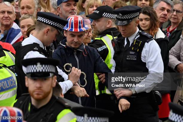 Protesters from climate protest group 'Just Stop Oil' are apprehended by police officers in the crowd during the Coronation of King Charles III and...