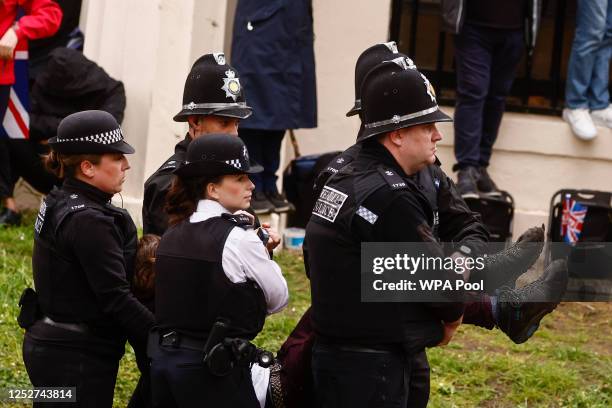 Police officers detain a member of "Just Stop Oil" movement during a protest ahead of King Charles' procession to his coronation ceremony from...