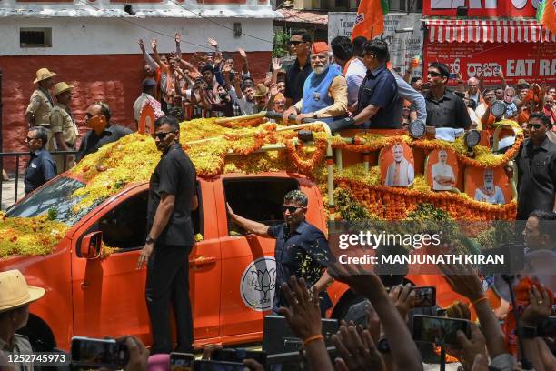 Indian Prime Minister Narendra Modi looks at supporters from atop a vehicle during a road rally held by the Bharatiya Janata Party in Bengaluru on...
