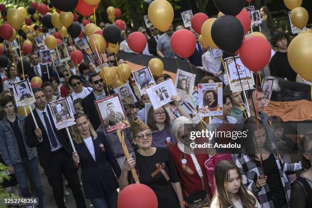 People attend the "Immortal Regiment" march organized by the Russian Language Instructors and Translators Association as part of the 9 May Victory...