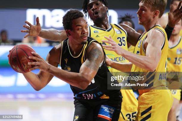 Cameron Jackson of Ludwigsburg is challenged by Landry Nnoko and Niels Giffey of Berlin during the EasyCredit Basketball Bundesliga final first leg...