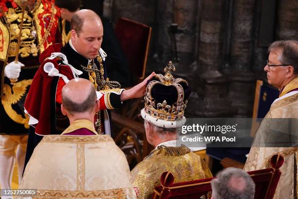 Prince William, Prince of Wales touches the St Edward's Crown his father's, King Charles III during the King's Coronation Ceremony inside Westminster...