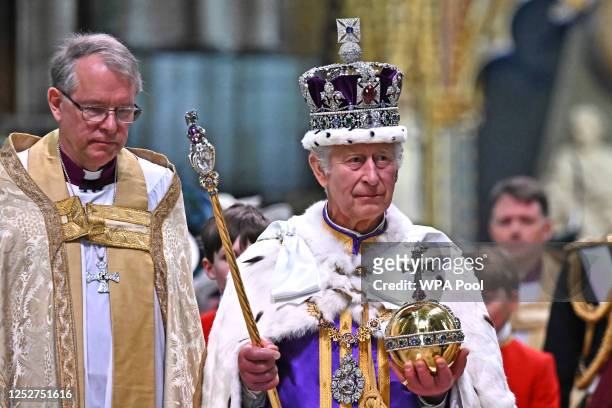 Britain's King Charles III wearing the Imperial state Crown carrying the Sovereign's Orb and Sceptre leaves Westminster Abbey after the Coronation...