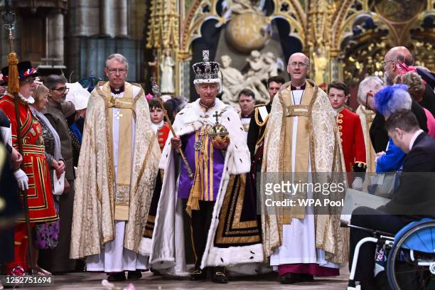 Britain's King Charles III wearing the Imperial state Crown carrying the Sovereign's Orb and Sceptre leaves Westminster Abbey after the Coronation...