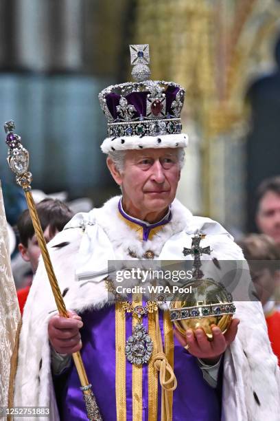 Britain's King Charles III wearing the Imperial state Crown carrying the Sovereign's Orb and Sceptre leaves Westminster Abbey after the Coronation...