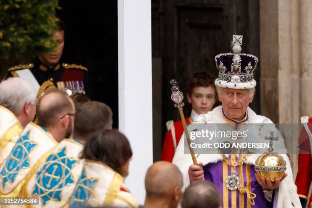 Britain's King Charles III wearing the Imperial state Crown carrying the Sovereign's Orb and Sceptre leaves Westminster Abbey after the Coronation...