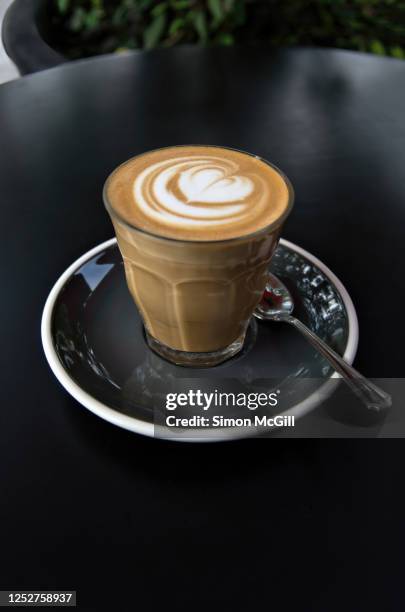 latte coffee served in a drinking glass cup on a saucer on a table at an outdoor cafe - guadalajara food stock pictures, royalty-free photos & images