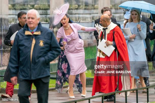 Singer Katy Perry stumbles as she leaves Westminster Abbey following the coronation ceremony of King Charles III and Queen Camilla in central London...