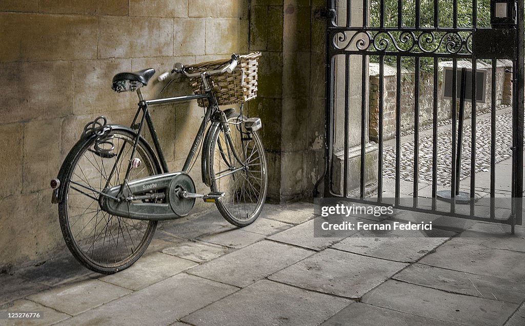 Cycle with basket in front leaning against wall