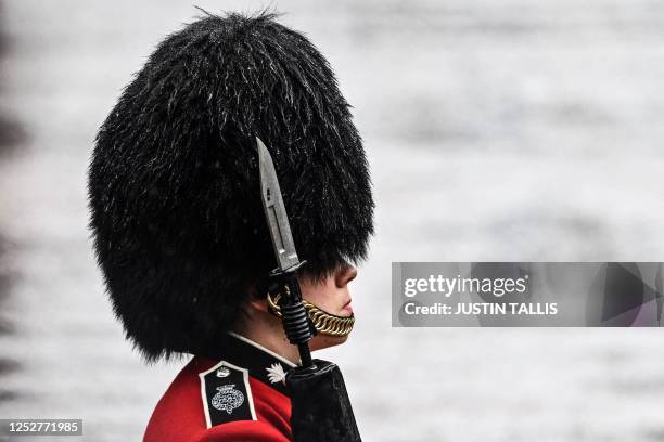 Guard with his hat wet stands guard along the Mall in central London on May 6 following the coronations of Britain's King Charles III and Britain's...