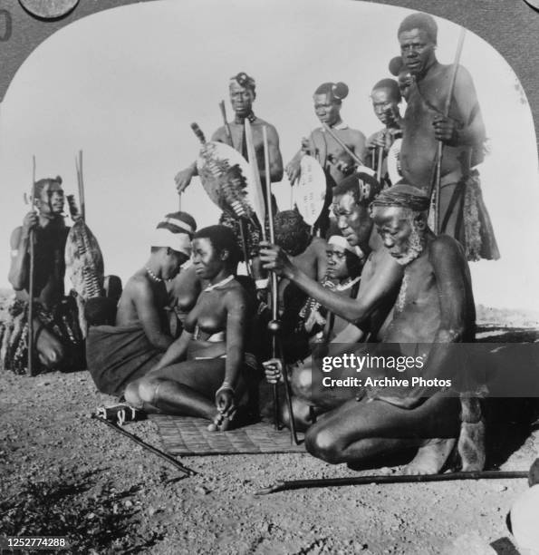 An elderly Zulu chief and his family of warriors near the Umlaloose River in Zululand , South Africa, circa 1900.