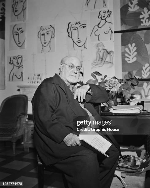 French artist Henri Matisse reading a book of poems by Yvan Goll at his desk in his villa in Vence, near Nice in the south of France, circa 1950. His...