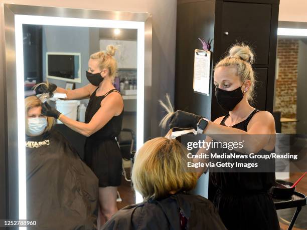 West Reading, PA Stephanie DeLozier, owner of Salon Avanti, works with customer Sue Henne of Wyomissing, while they both wear masks at Salon Avanti...