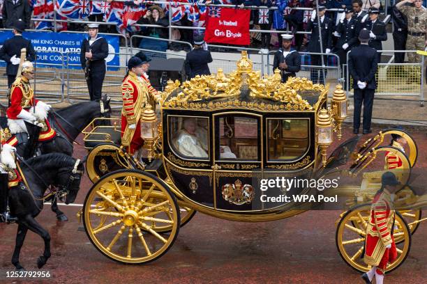 King Charles III and Camilla, Queen Consort travel in the Diamond Jubilee Coach as they leave Buckingham Palace ahead of the Coronation of King...