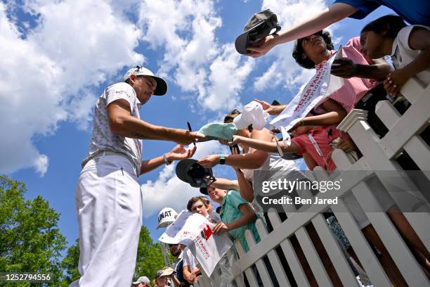 Rickie Fowler signs autographs for fans during the third round of the Wells Fargo Championship at Quail Hollow Club on May 6, 2023 in Charlotte,...
