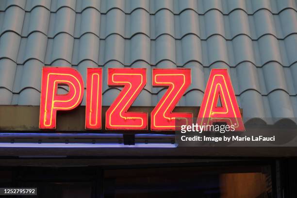 neon pizza sign on building - pizza stand stock pictures, royalty-free photos & images
